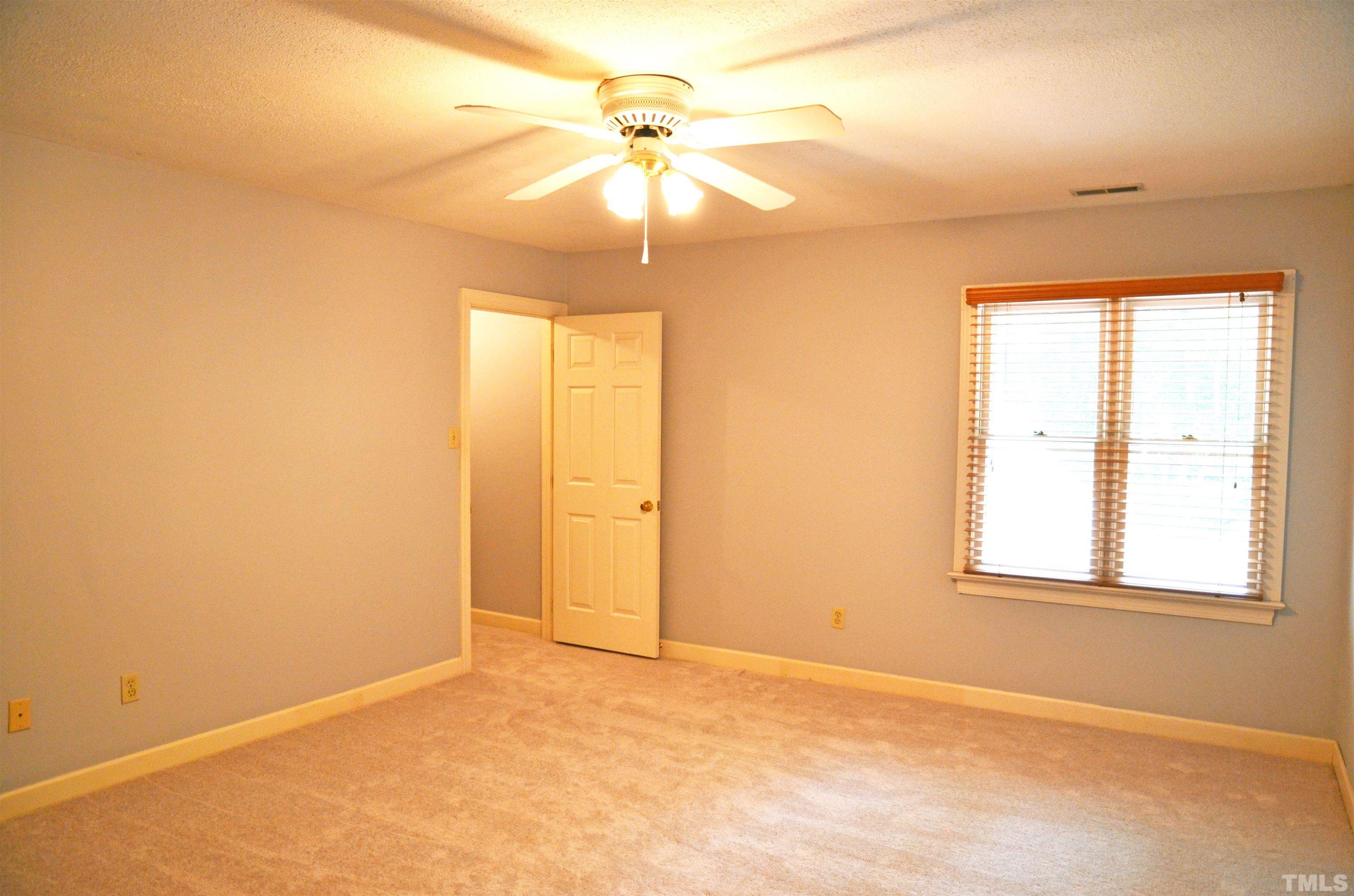 4907 Old Elizabeth Road Raleigh, NC 27616 - Photo 5 of 30 an empty room with windows and chandelier fan