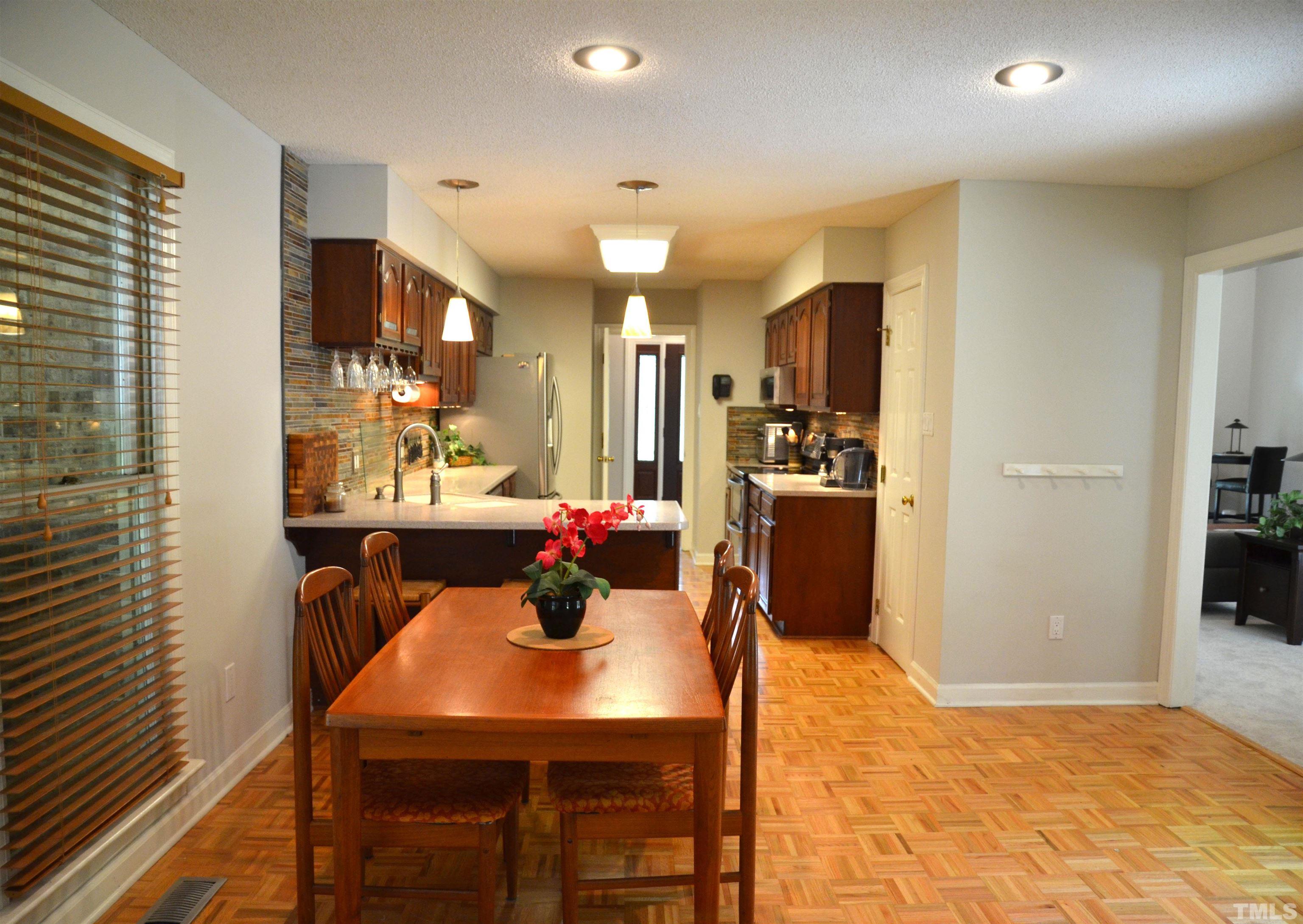 4907 Old Elizabeth Road Raleigh, NC 27616 - Photo 8 of 30 a kitchen with stainless steel appliances kitchen island granite countertop a refrigerator a stove a sink dishwasher with a dining table and chairs