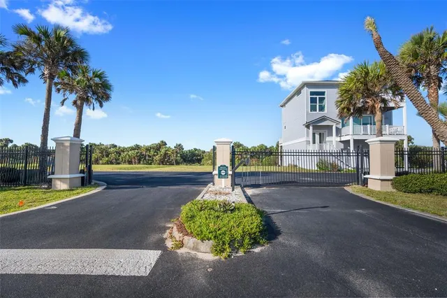 a front view of a house with a yard and palm trees