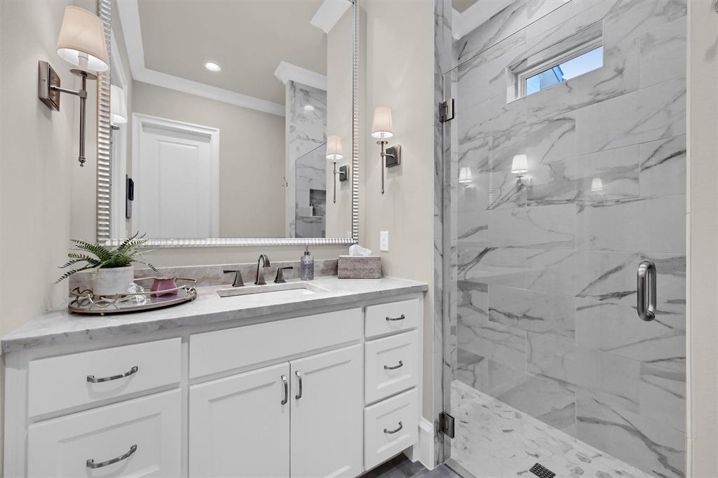 8301 Stephens Ranch Road Pilot Point, TX 76258 - Photo 27 of 40 a bathroom with a granite countertop sink a mirror a vanity and shower