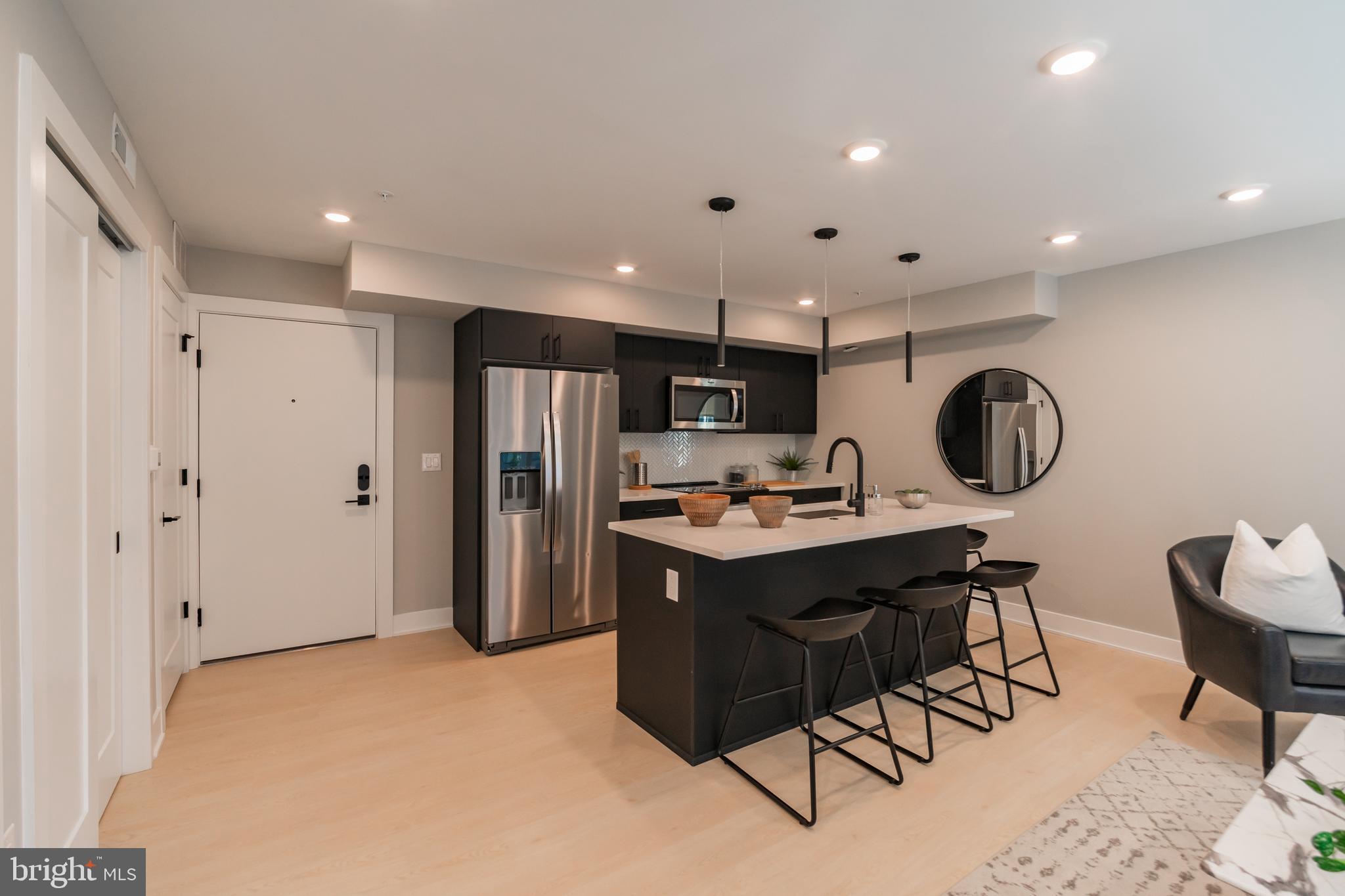 6604 Ridge Avenue, Unit 503 Philadelphia, PA 19128 - Photo 5 of 11 a kitchen with stainless steel appliances granite countertop a sink refrigerator and cabinets