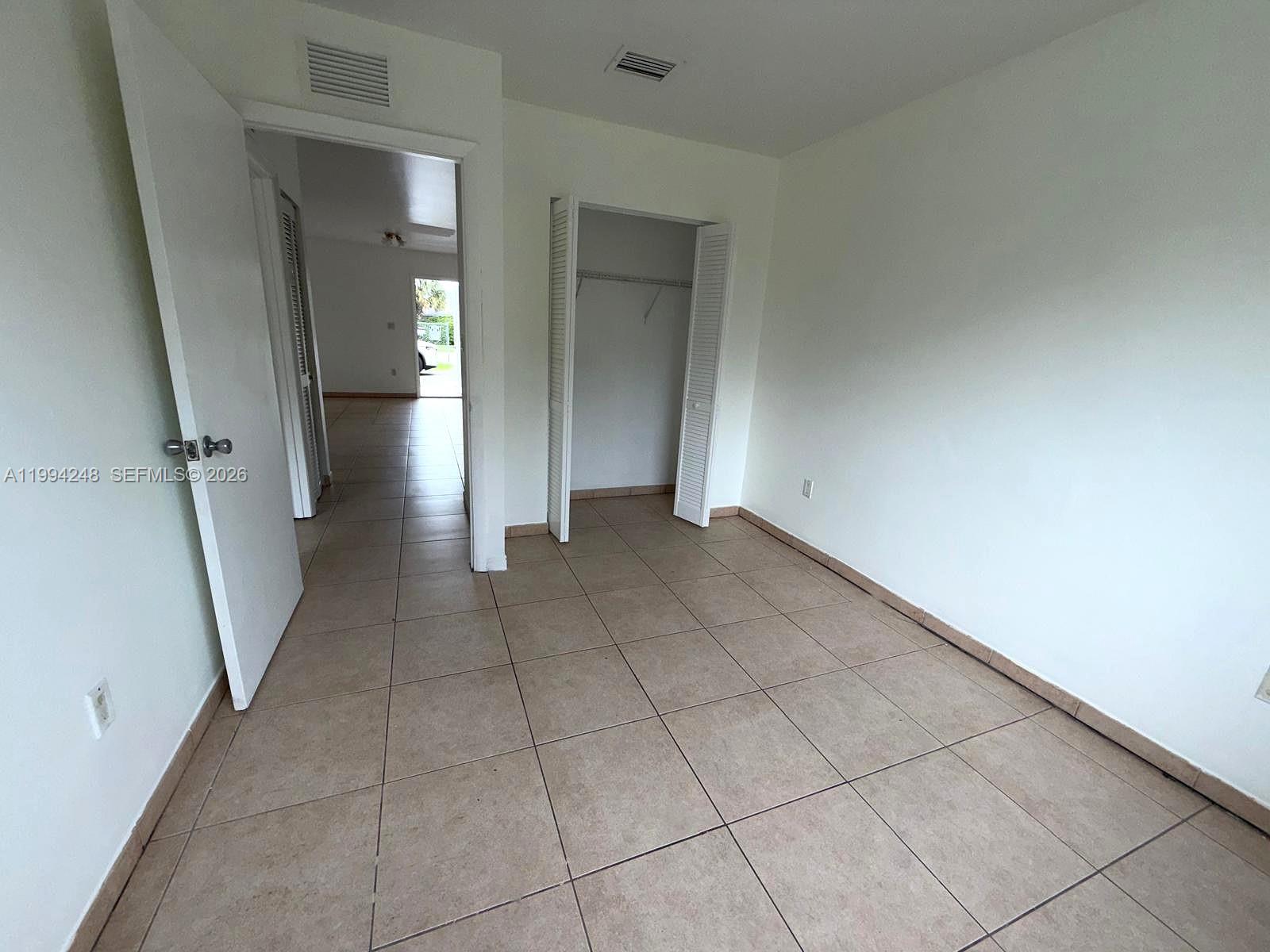 14140 Northeast 2nd Court, Unit 2 Miami, FL 33161 - Photo 11 of 13 an empty room with a mirror