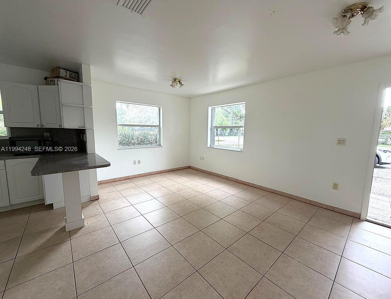 14140 Northeast 2nd Court, Unit 2 Miami, FL 33161 - Photo 4 of 13 a view of an empty room with a window
