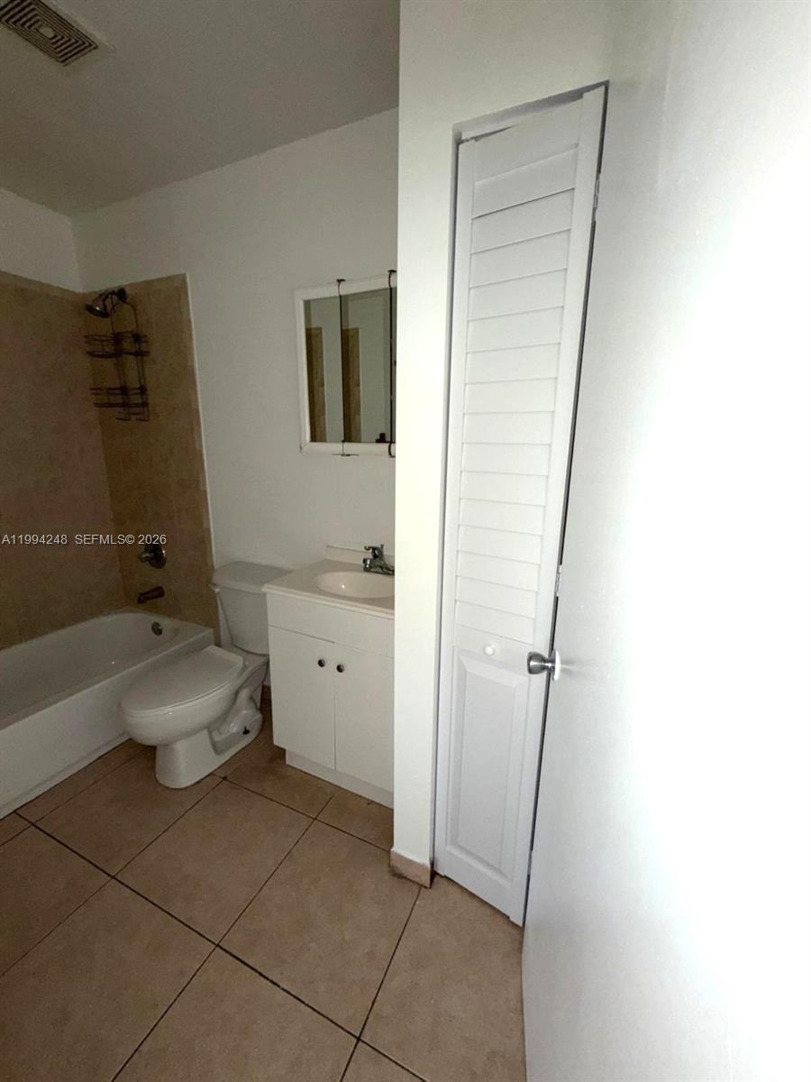 14140 Northeast 2nd Court, Unit 2 Miami, FL 33161 - Photo 6 of 13 a bathroom with a sink a toilet and shower