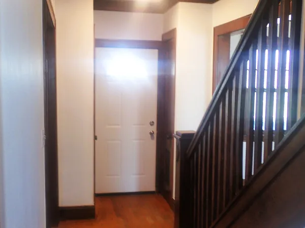 a view of a hallway with wooden floor and entryway