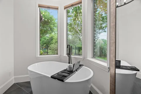 a white bath tub sitting in a bathroom next to a window