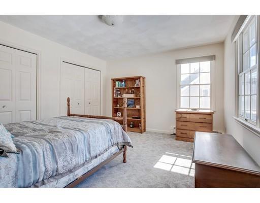 22 Battle Flagg Road Bedford, MA 01730 - Photo 22 of 30 a spacious bedroom with a bed a dresser and book shelf