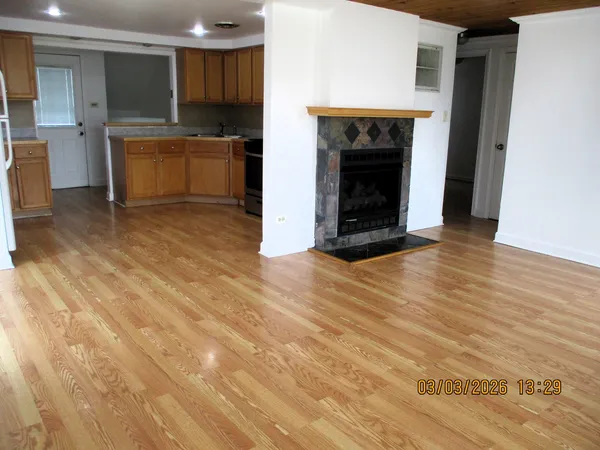 a view of an empty room with a fireplace and a window
