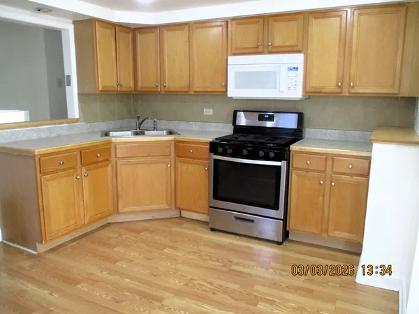 a kitchen with stainless steel appliances granite countertop a stove a sink and a microwave