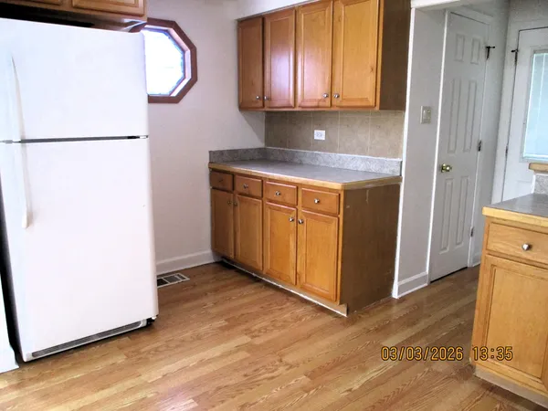 a kitchen with a refrigerator sink and cabinets