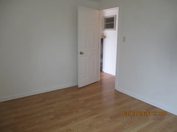 an empty room with wooden floor and closet
