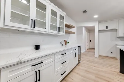 a kitchen with stainless steel appliances cabinets and wooden floor