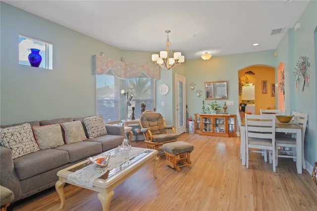 a living room with furniture a dining table and a chandelier