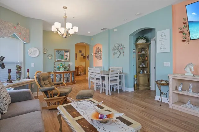 a living room with furniture and a chandelier