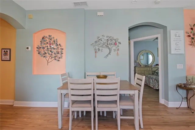 a dining room with furniture and wooden floor