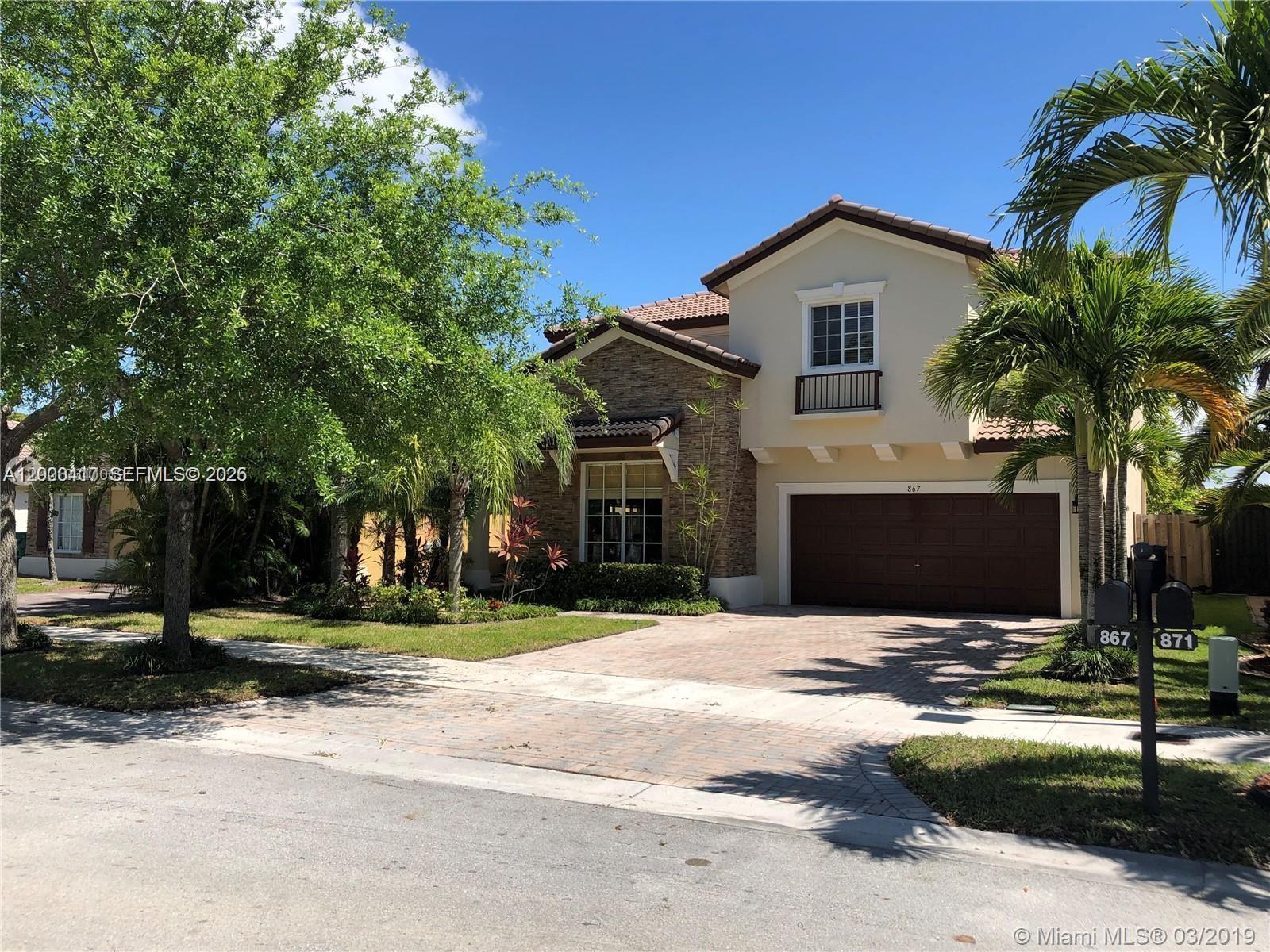 867 Southwest 155th Court, Unit 867 Miami, FL 33194 - Photo 1 of 25 a front view of a house with a yard and garage