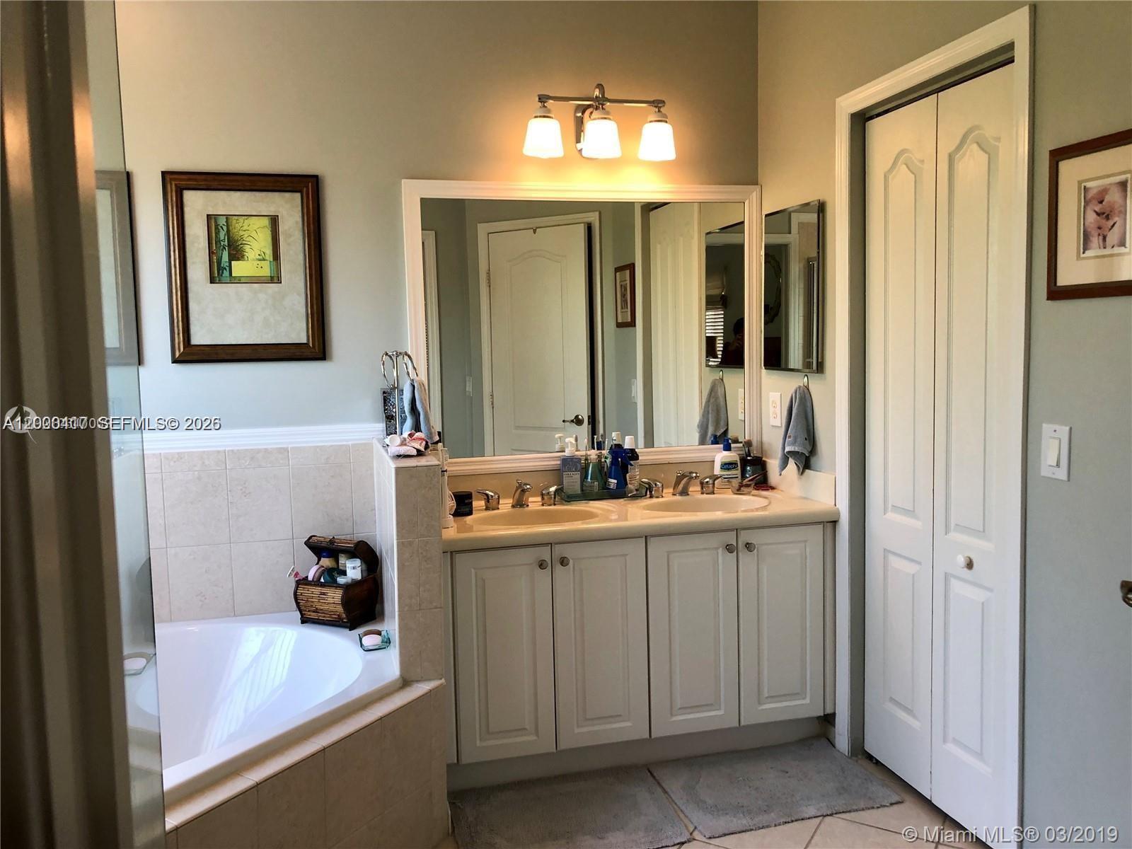 867 Southwest 155th Court, Unit 867 Miami, FL 33194 - Photo 14 of 25 a bathroom with a tub sink and mirror