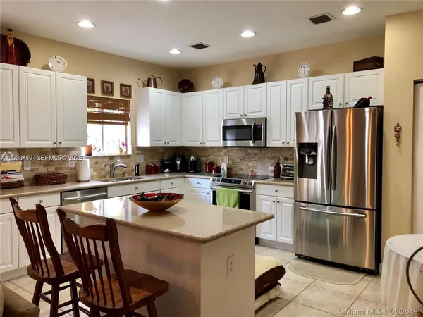 a kitchen with a refrigerator a stove a sink and a microwave