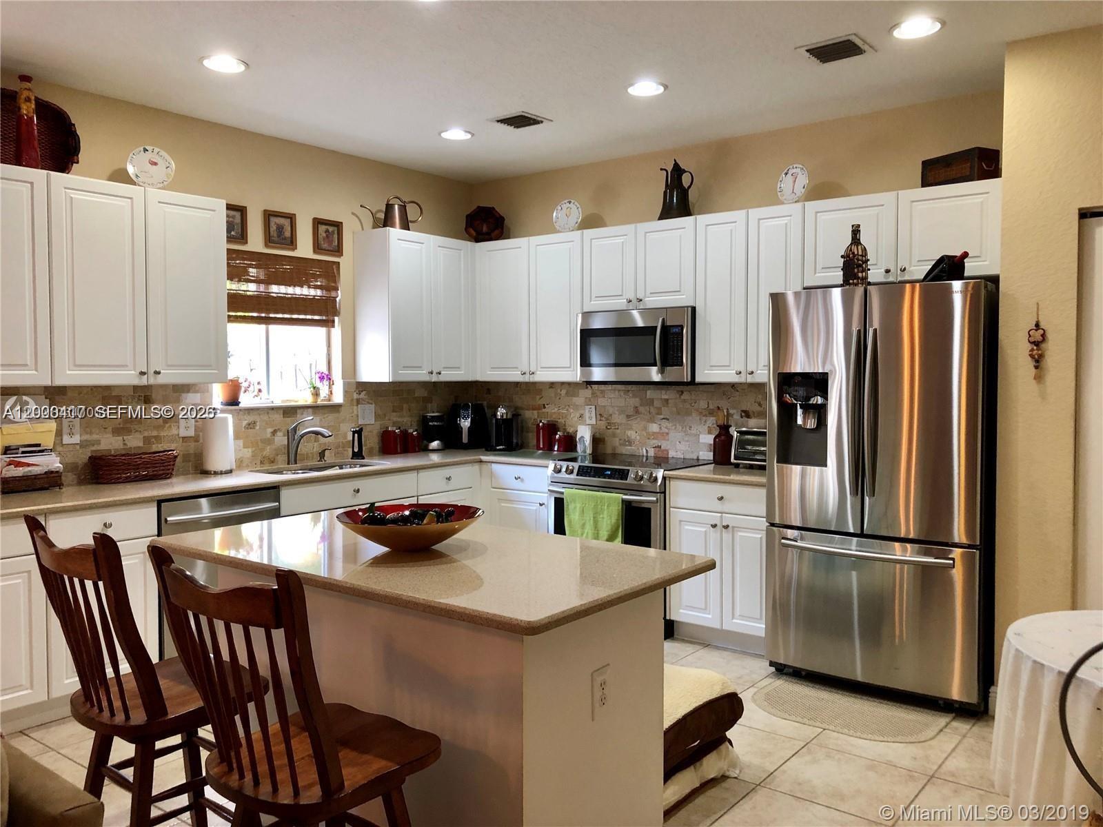 867 Southwest 155th Court, Unit 867 Miami, FL 33194 - Photo 7 of 25 a kitchen with a refrigerator a stove a sink and a microwave