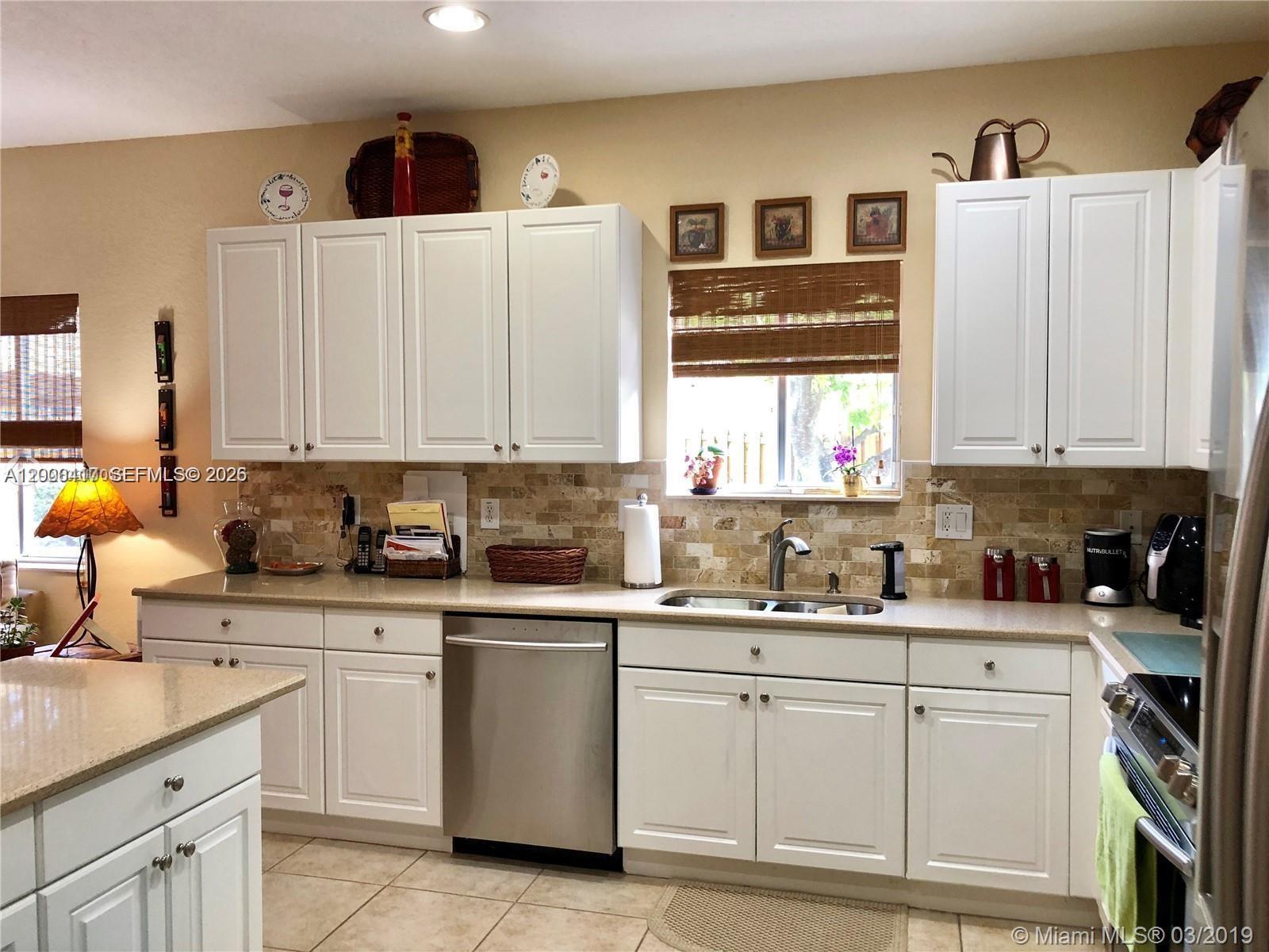 867 Southwest 155th Court, Unit 867 Miami, FL 33194 - Photo 8 of 25 a kitchen with appliances cabinets and a sink