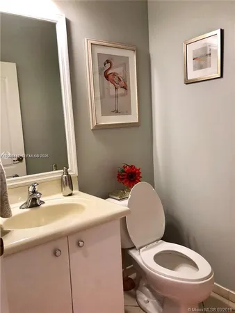 a bathroom with a toilet a sink and mirror