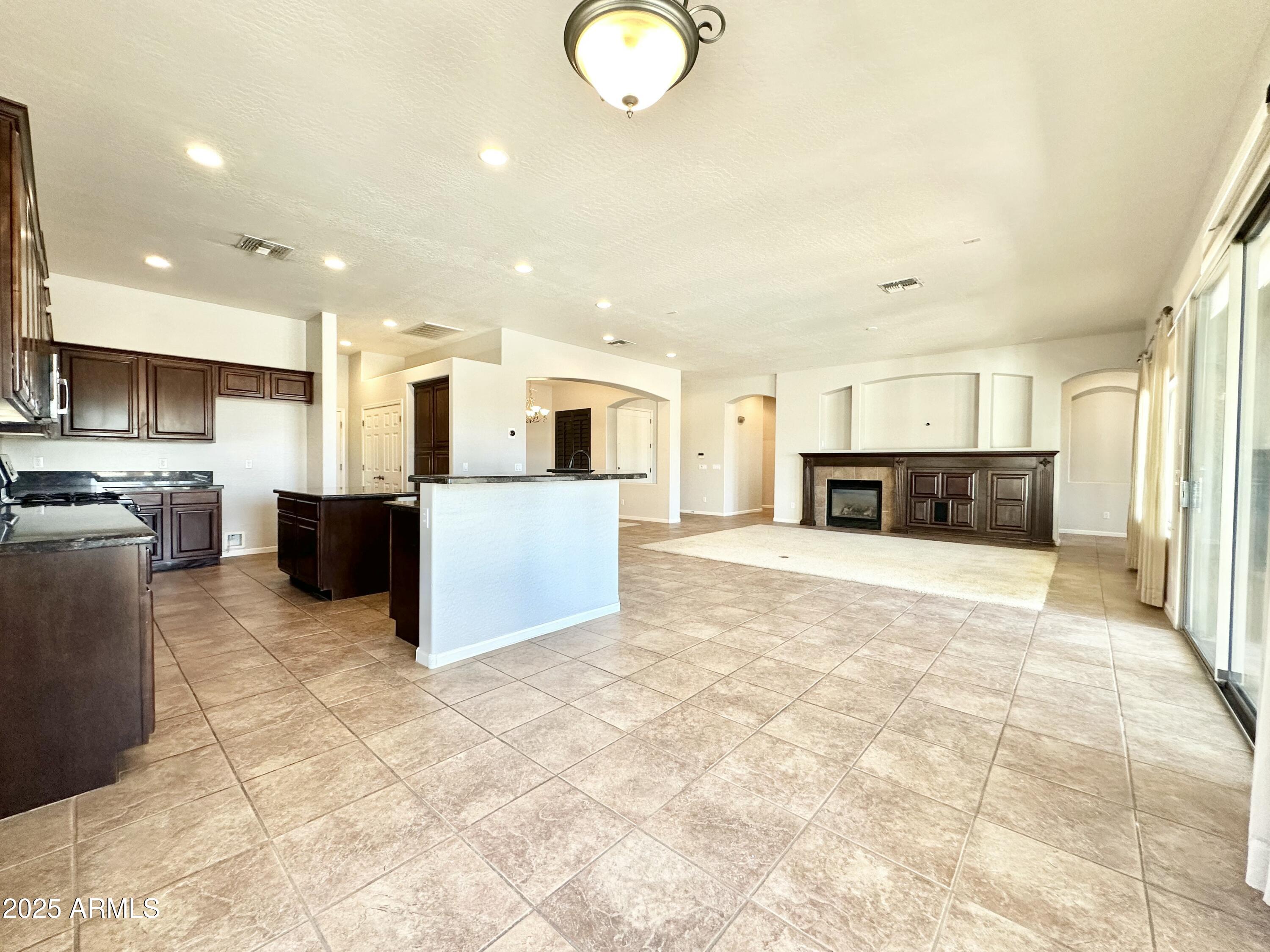 6562 South Crestview Drive Gilbert, AZ 85298 - Photo 11 of 23 a large kitchen with stainless steel appliances granite countertop a refrigerator and a stove top oven