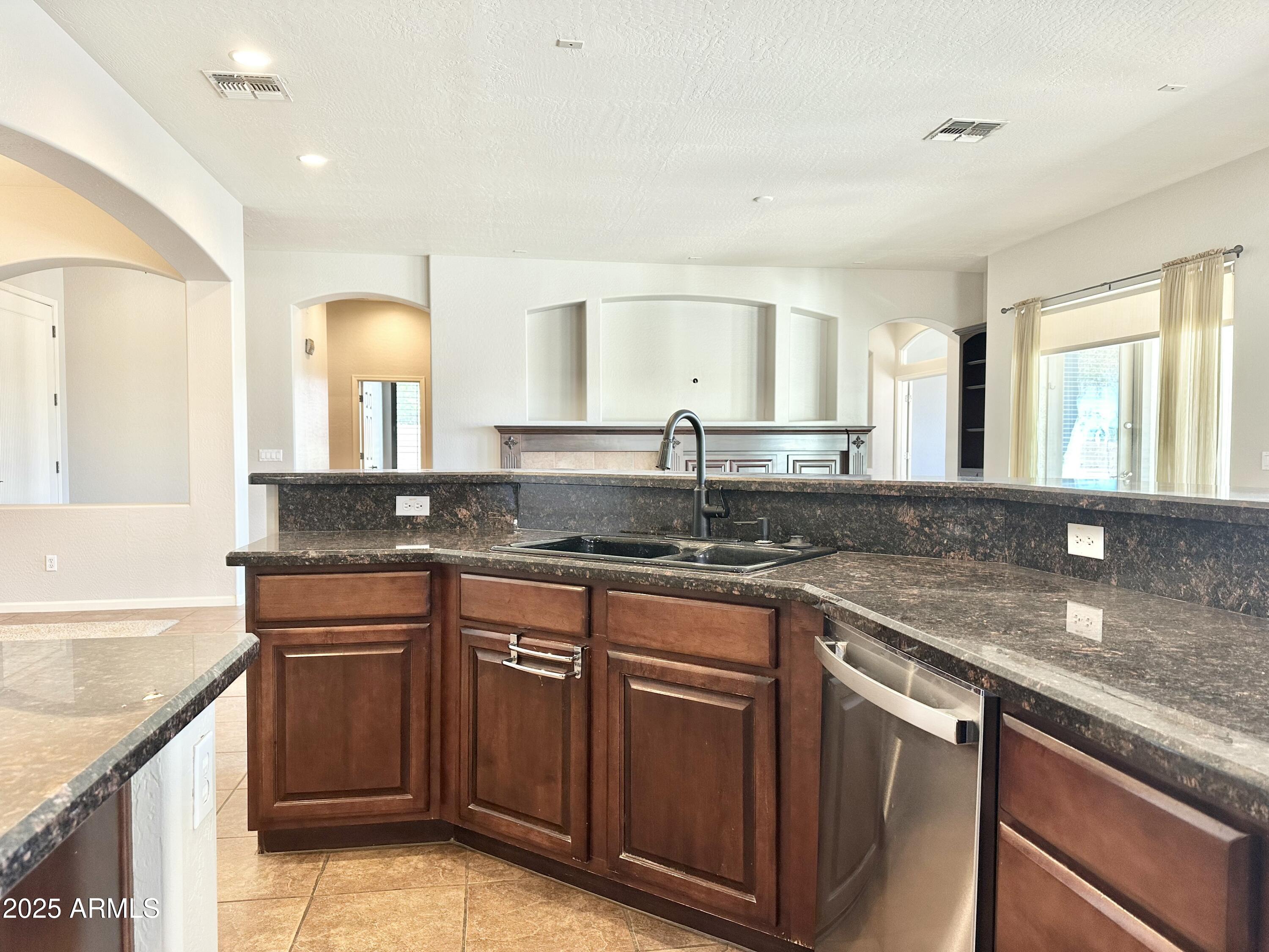 6562 South Crestview Drive Gilbert, AZ 85298 - Photo 9 of 23 a kitchen with stainless steel appliances granite countertop a sink stove and cabinets