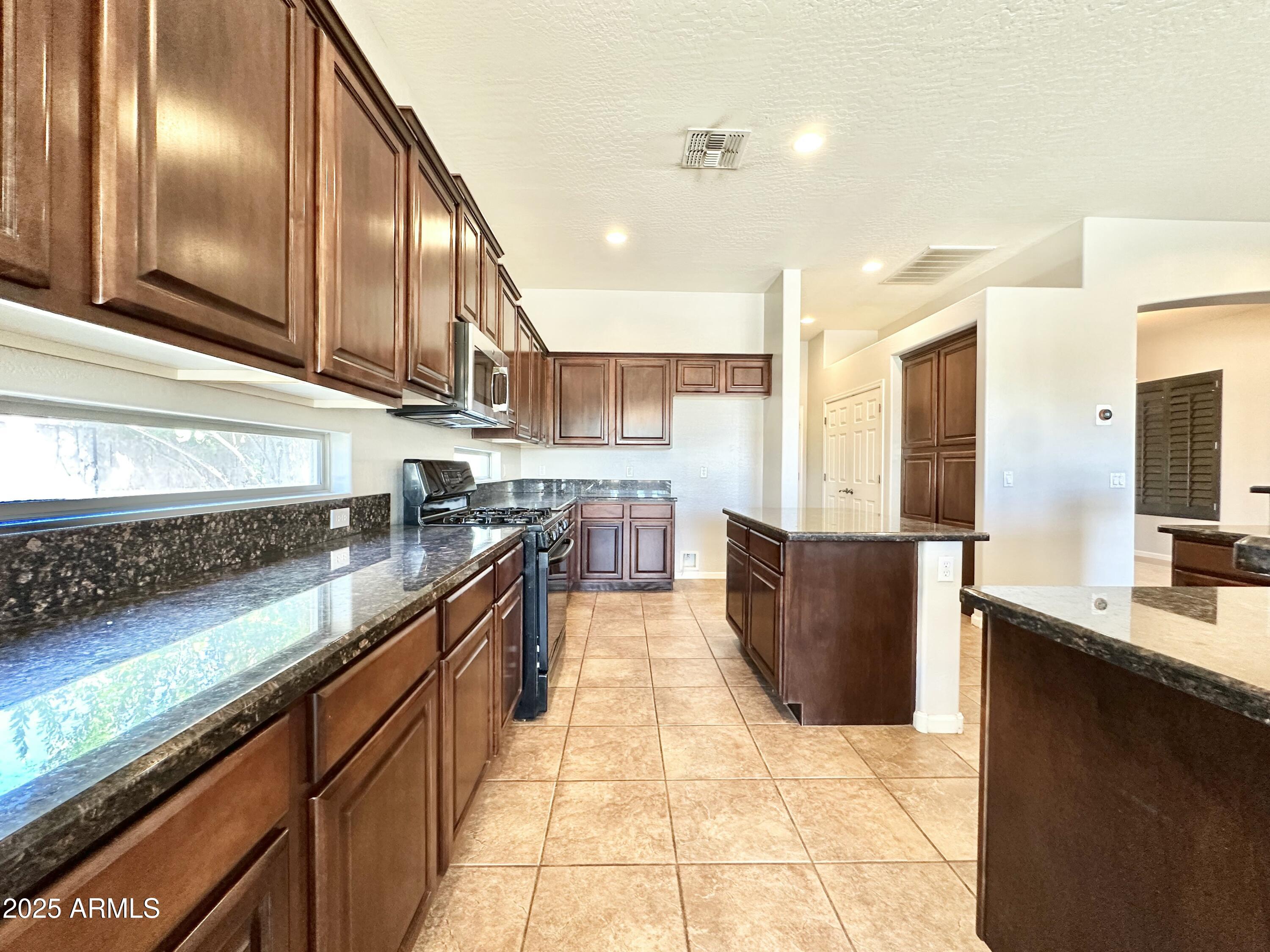 6562 South Crestview Drive Gilbert, AZ 85298 - Photo 10 of 23 a large kitchen with stainless steel appliances and large counter top
