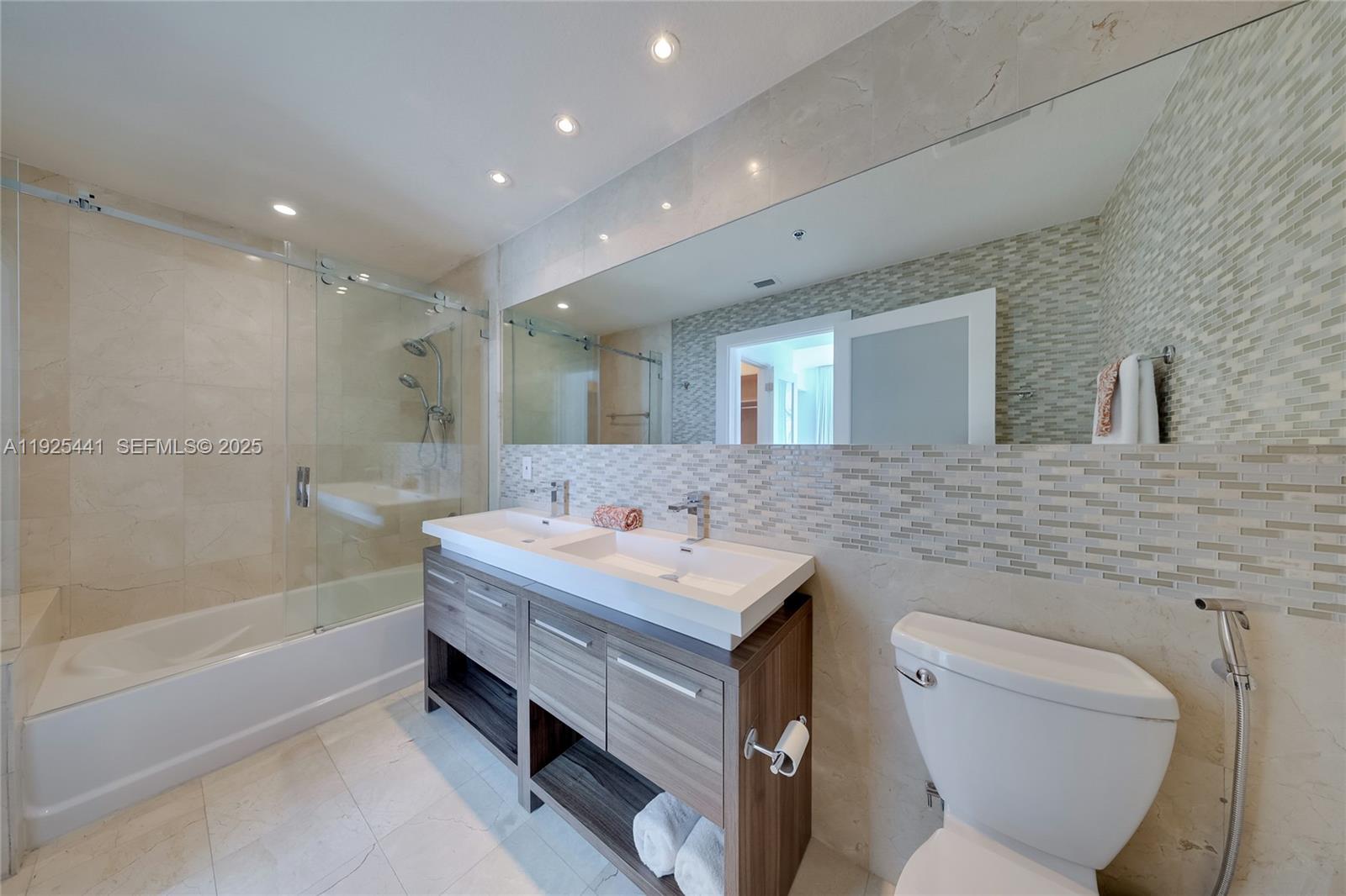 6515 Collins Avenue, Unit 605 Miami Beach, FL 33141 - Photo 11 of 18 a bathroom with a sink toilet vanity and bathtub