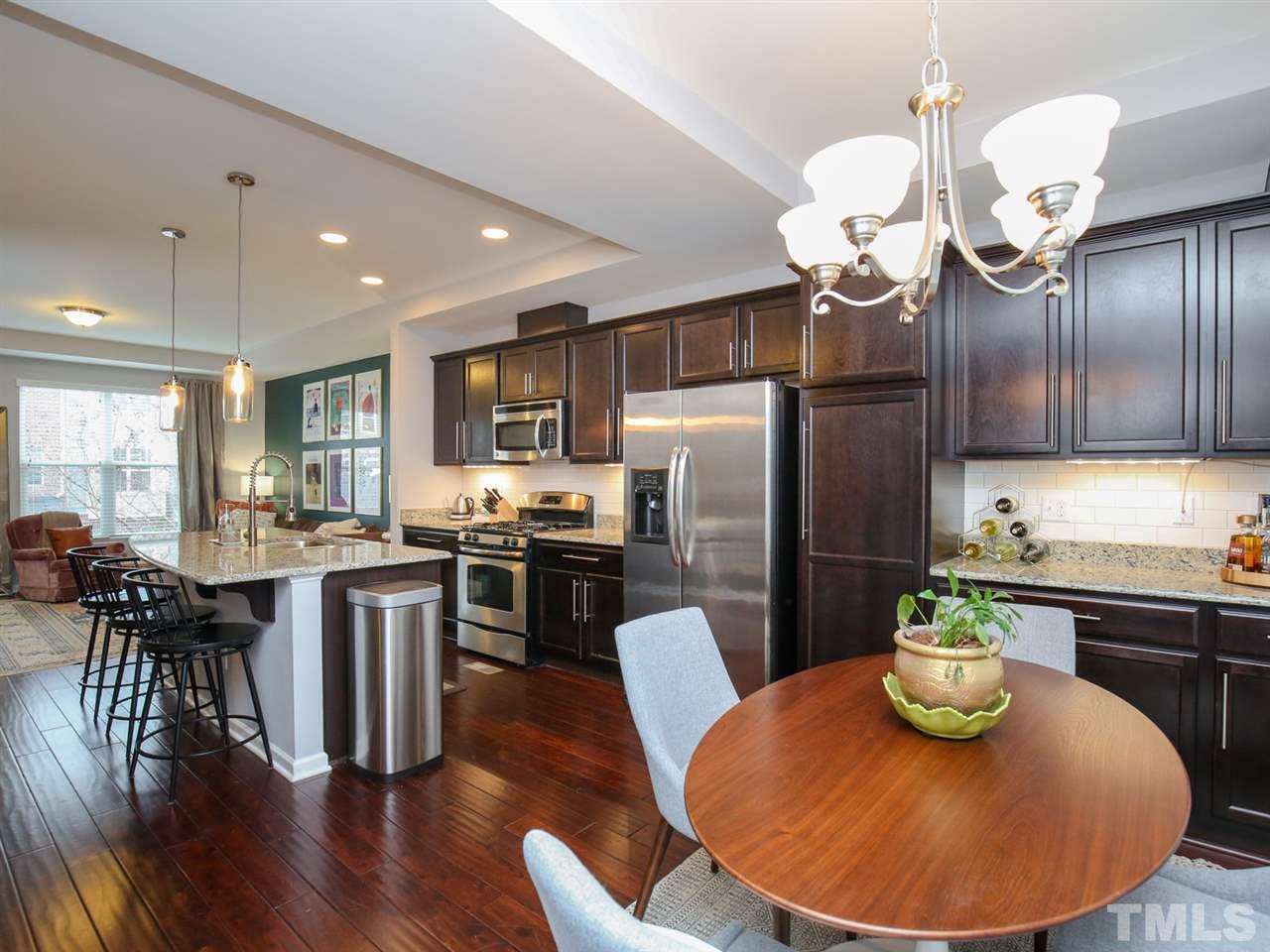 1415 Ardara Lane Raleigh, NC 27607 - Photo 3 of 30 a kitchen with stainless steel appliances granite countertop a sink a refrigerator dining table and chairs