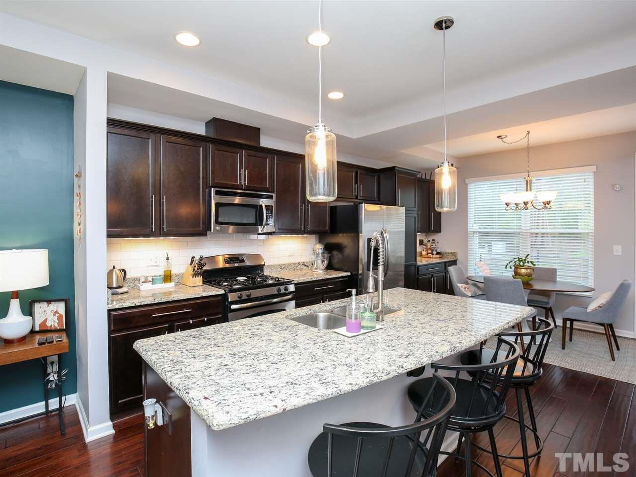 1415 Ardara Lane Raleigh, NC 27607 - Photo 4 of 30 a kitchen with refrigerator cabinets dining table and chairs