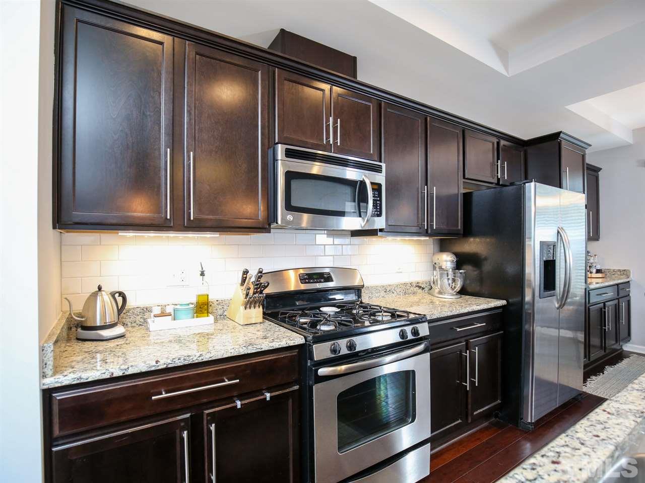 1415 Ardara Lane Raleigh, NC 27607 - Photo 5 of 30 a kitchen with granite countertop stainless steel appliances and wooden cabinets