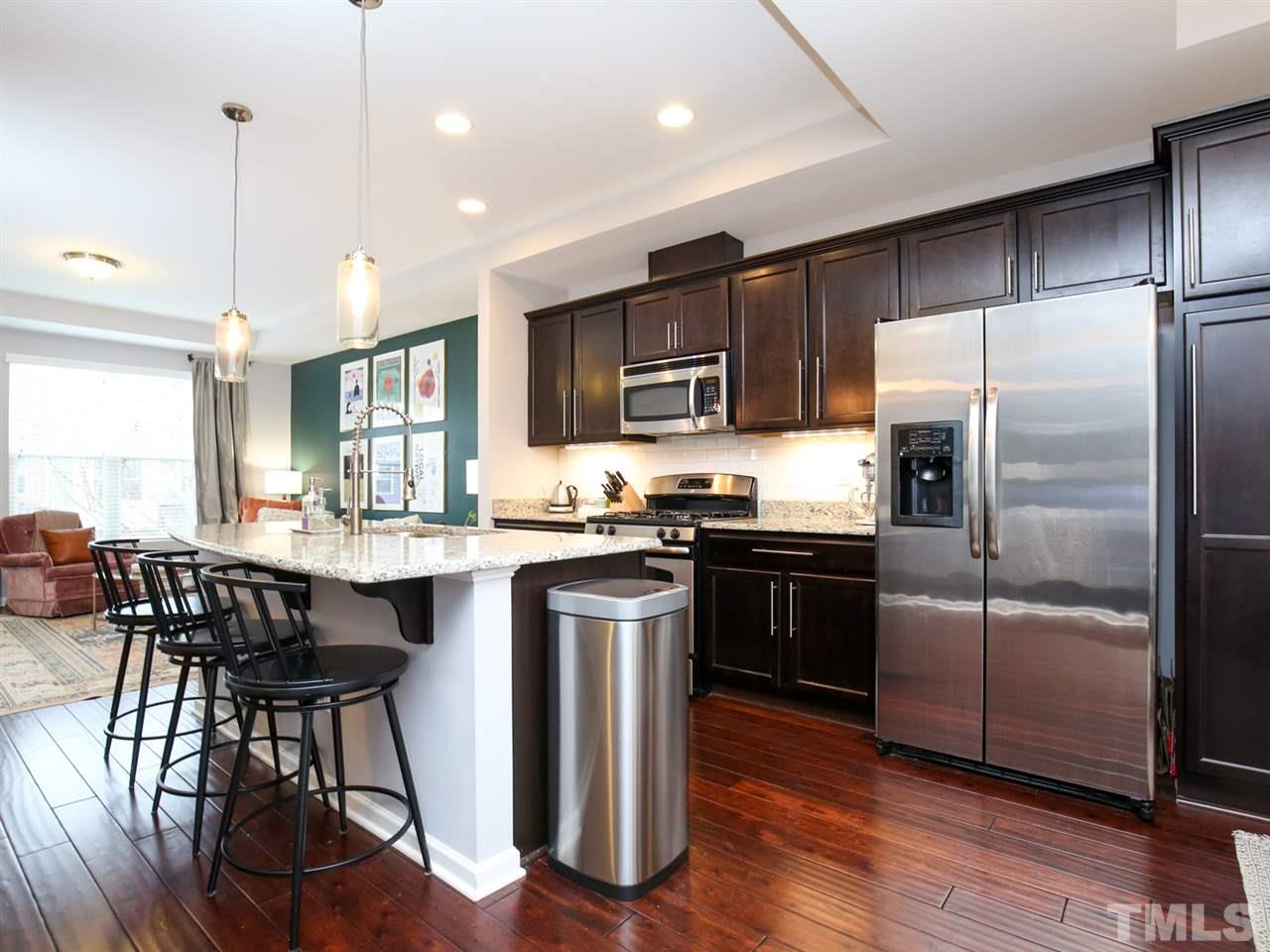 1415 Ardara Lane Raleigh, NC 27607 - Photo 6 of 30 a kitchen with stainless steel appliances granite countertop a refrigerator a stove a sink a dining table and chairs
