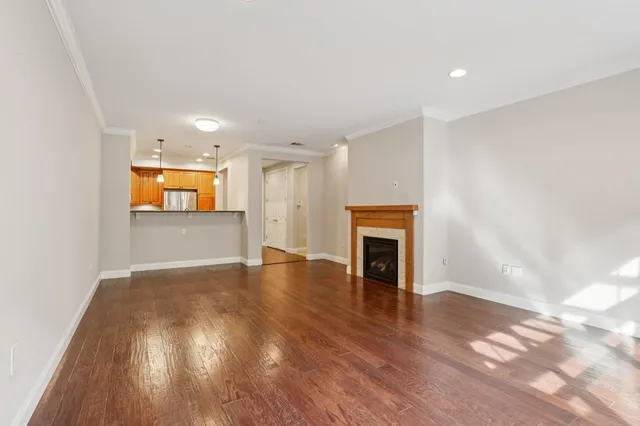 a view of a livingroom with a fireplace a chandelier and wooden floor