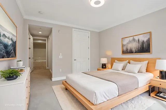 a bedroom with a bed and painting on the wall