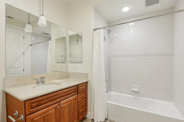 a bathroom with a sink double vanity granite tub shower and a mirror