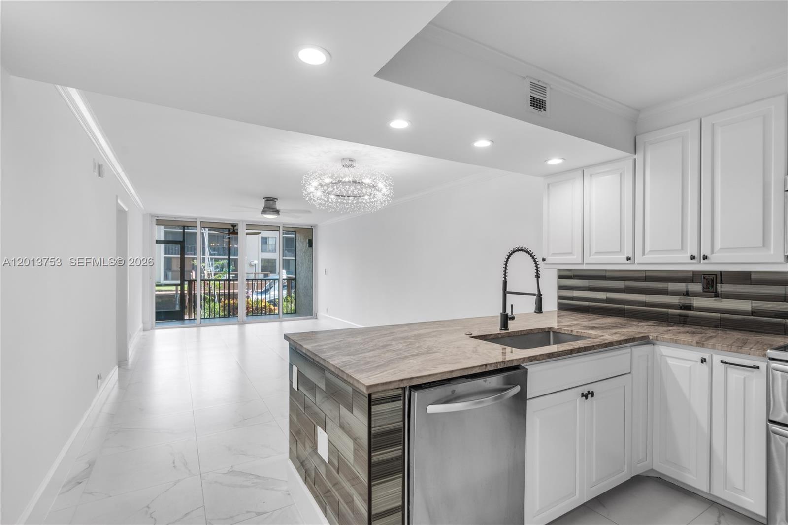 a kitchen with granite countertop a sink and white cabinets