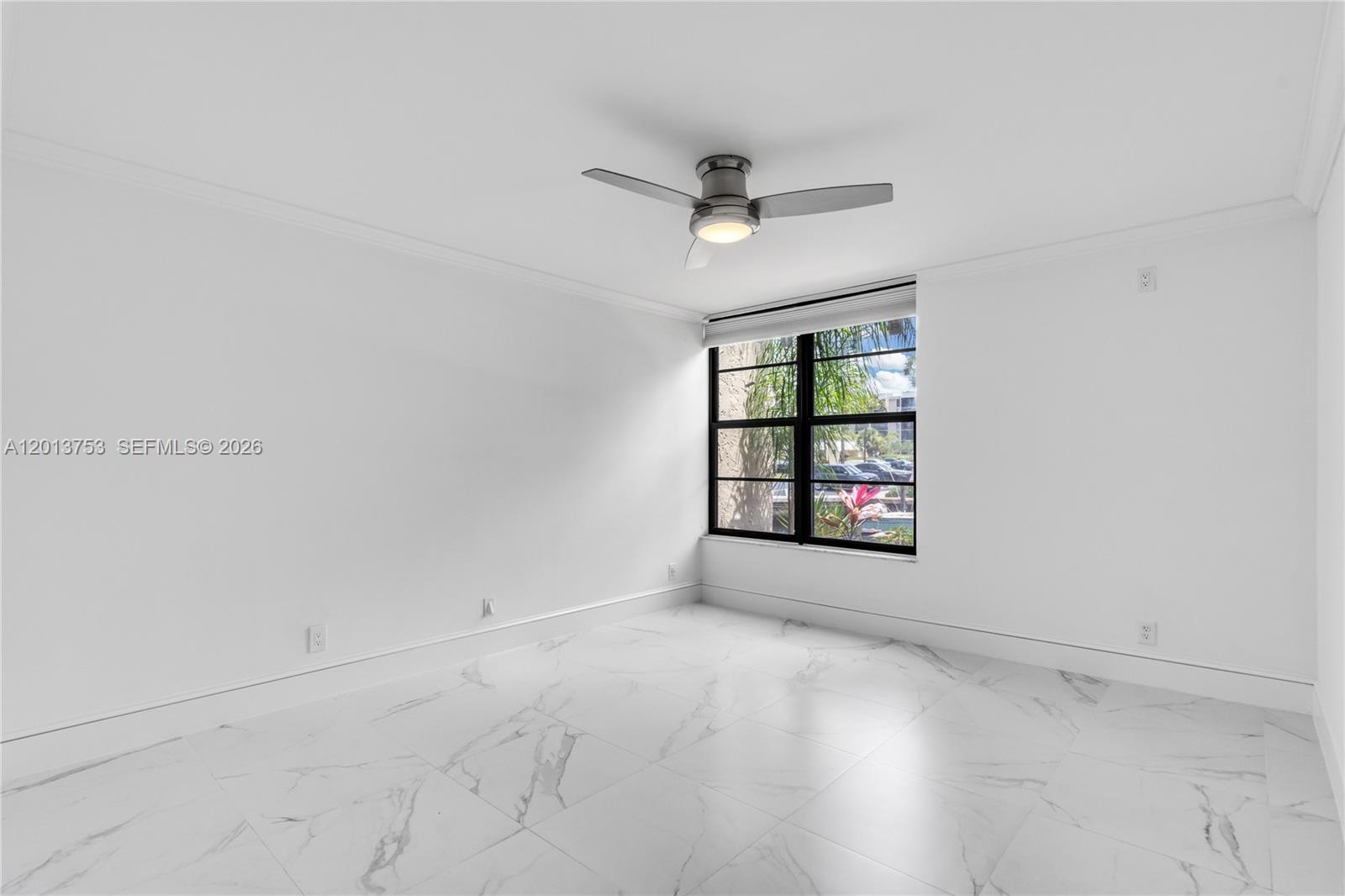 12 Royal Palm Way, Unit 103 Boca Raton, FL 33432 - Photo 9 of 22 an empty room with a window and ceiling fan