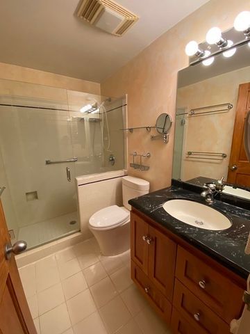 a bathroom with a granite countertop sink mirror vanity and toilet