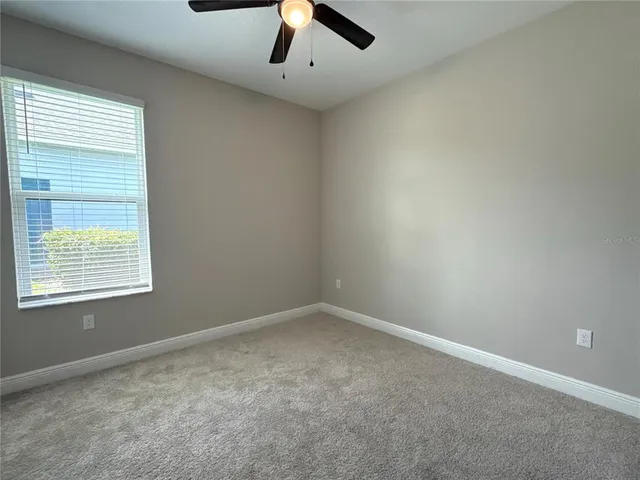an empty room with closet and a ceiling fan