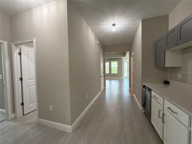 a hallway with wooden floor windows and entryway