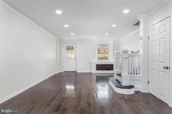 a view of a livingroom with wooden floor and a fireplace