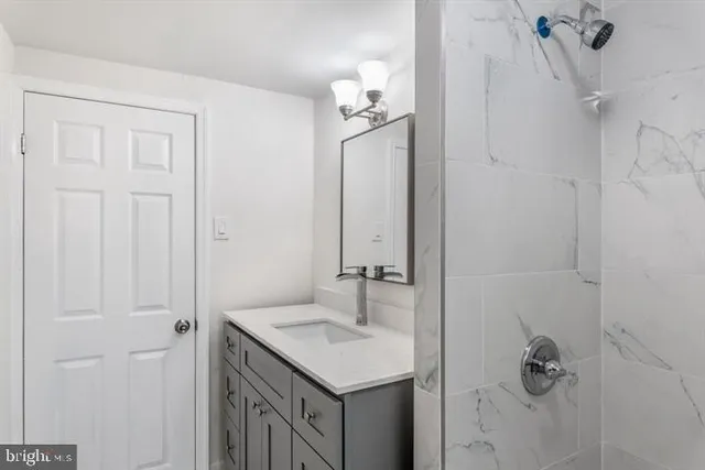 a bathroom with a sink vanity and shower