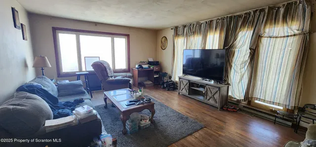 a living room with furniture tv and a window