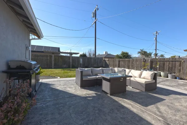 a view of a patio with couches chairs and wooden floor