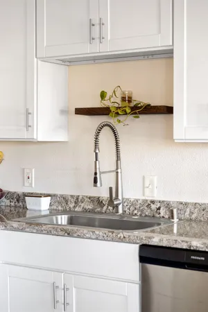 a kitchen with granite countertop a sink and cabinets