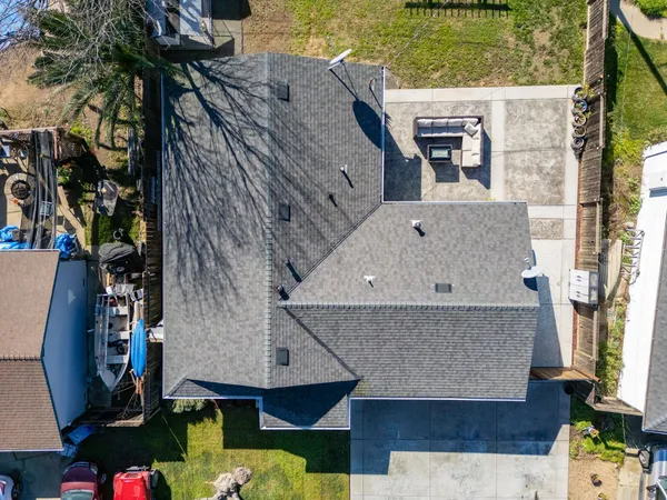 an aerial view of a house with swimming pool and large trees