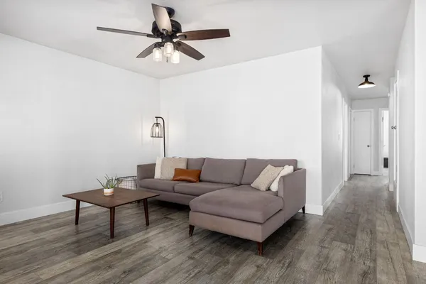 a living room with furniture and a wooden floor