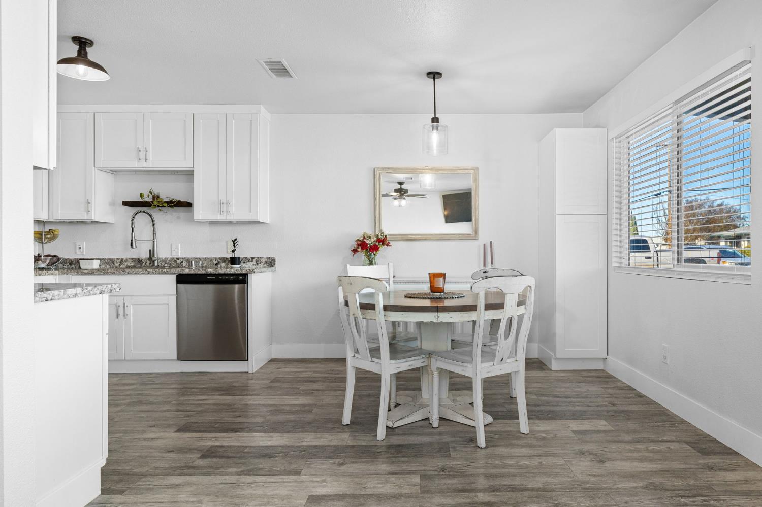 30 3rd Avenue Isleton, CA 95641 - Photo 8 of 42 a kitchen with stainless steel appliances kitchen island granite countertop a wooden floor and white cabinets