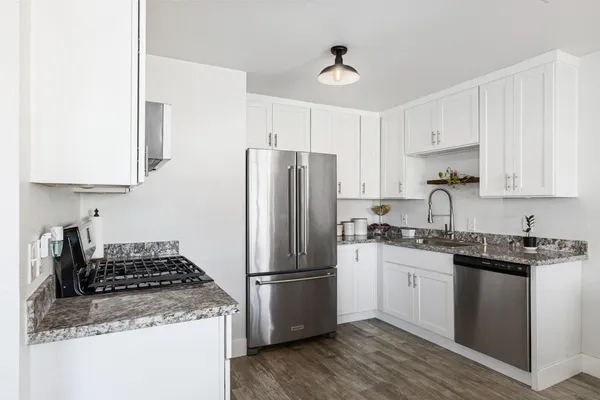 a kitchen with stainless steel appliances granite countertop a stove a refrigerator and a sink